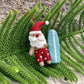 Pashom Santa with red shorts & blue surfboard